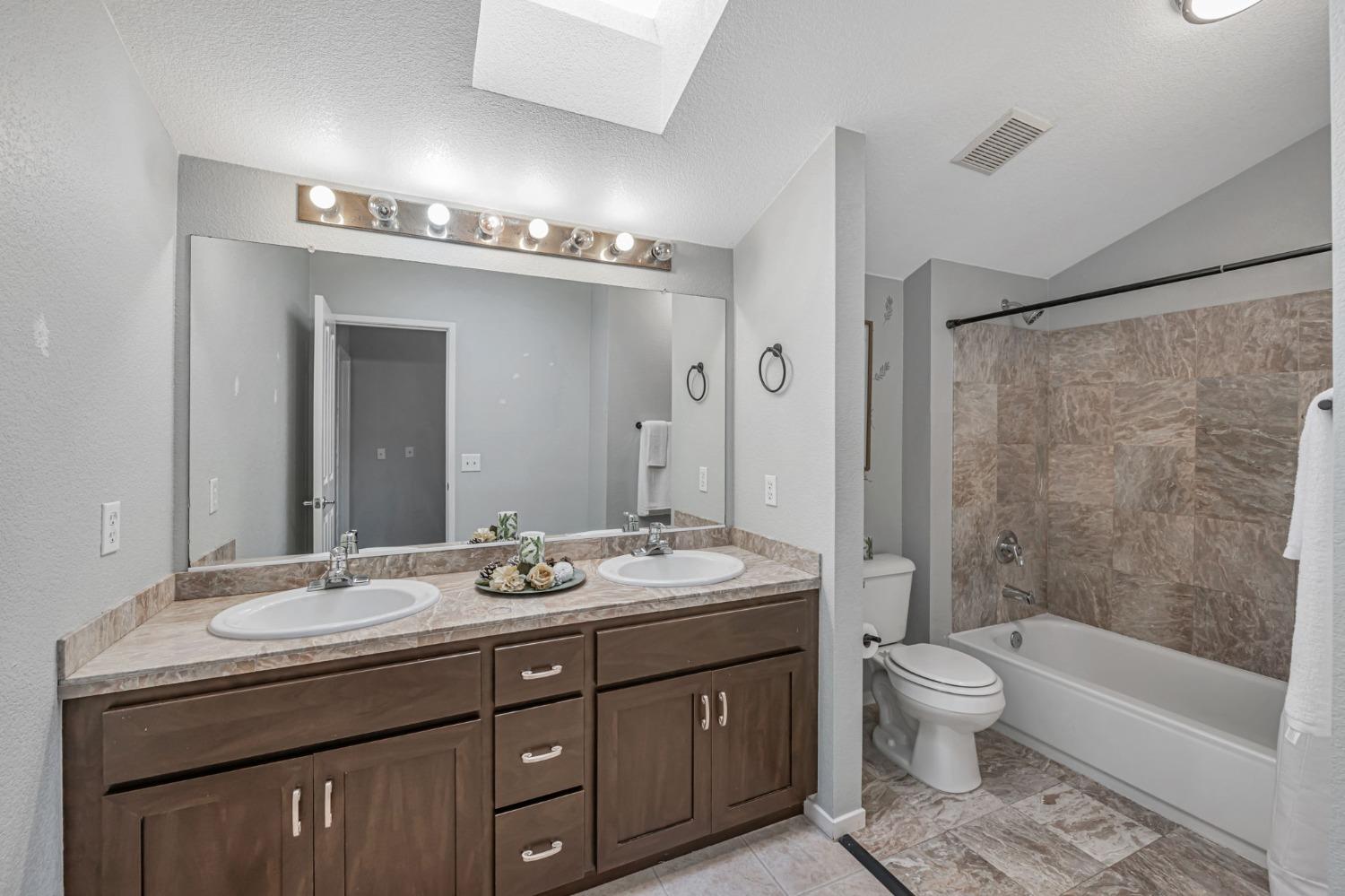 9065 Robbins Road Sacramento, CA 95829 - Photo 33 of 45 a bathroom with a granite countertop sink toilet mirror and bathtub
