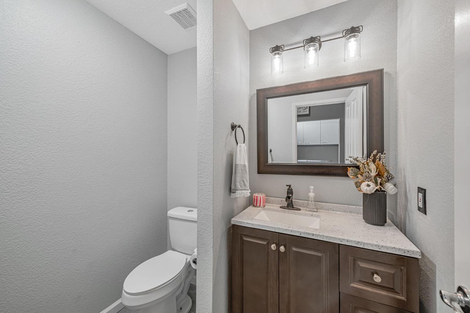 9065 Robbins Road Sacramento, CA 95829 - Photo 37 of 45 a bathroom with a granite countertop sink vanity mirror and toilet