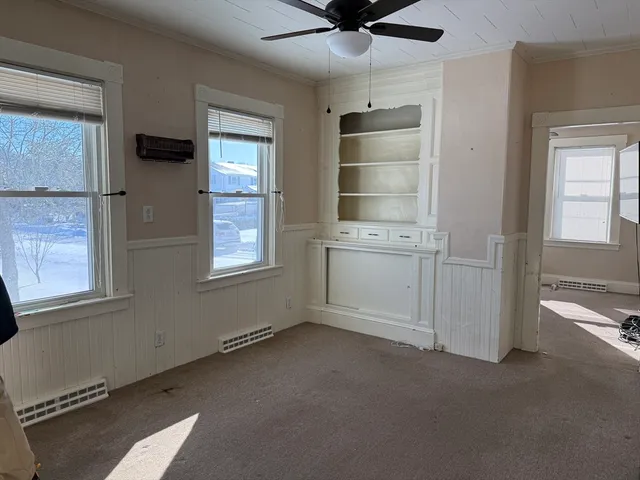 an empty room with windows and cabinet