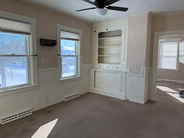 an empty room with windows and cabinet