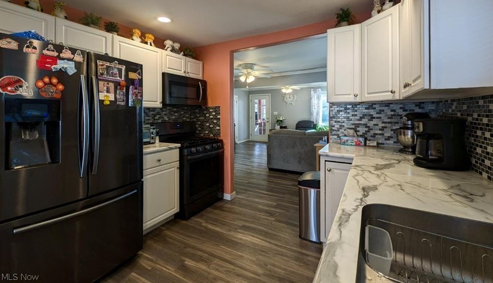 41 Poplar Street Huron, OH 44839 - Photo 36 of 37 Kitchen with black appliances, white cabinetry, open floor plan, and light stone counters