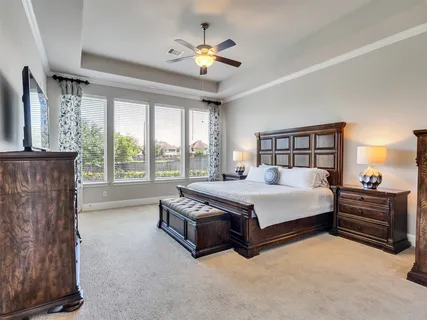 a spacious bedroom with a bed and a chandelier