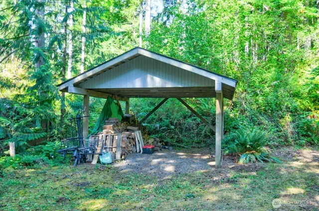 a backyard of a house with table and chairs under an umbrella