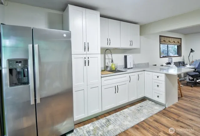 a kitchen with white cabinets and refrigerator