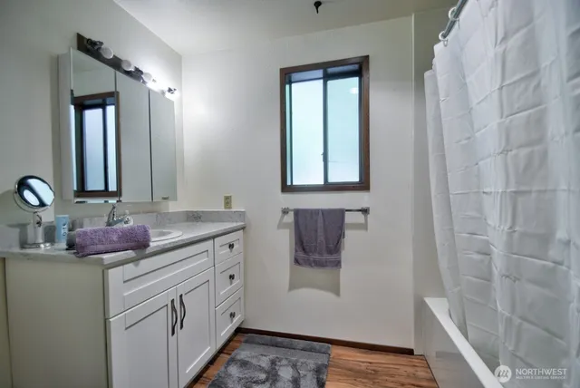 a bathroom with a granite countertop sink and a mirror