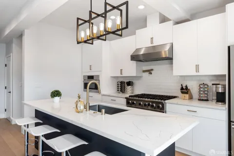 a kitchen with stainless steel appliances a sink a stove and cabinets