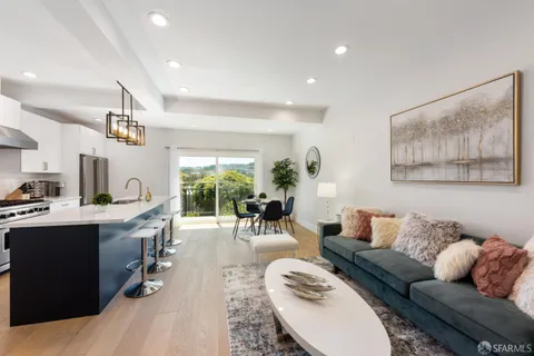 a living room with furniture kitchen view and a large window