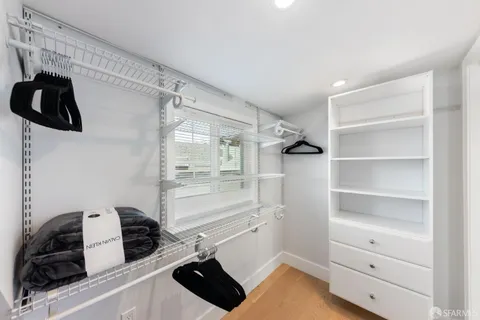 a view of walk in closet with clothes and shoes