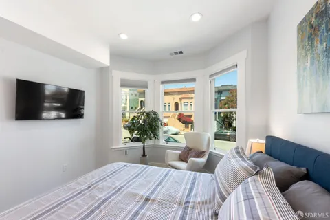 a bedroom with a large bed and a flat screen tv