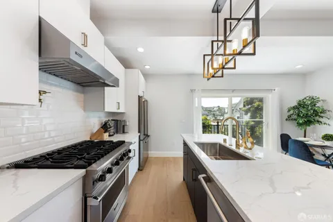 a kitchen with stainless steel appliances a sink a stove and cabinets