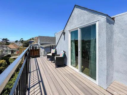 a view of a balcony with wooden floor and fence
