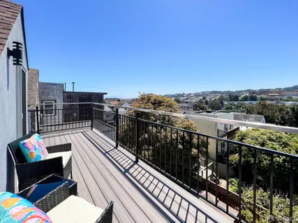 a balcony with wooden floor outdoor seating and city view