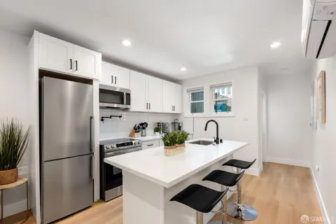a kitchen with stainless steel appliances a sink a microwave a refrigerator and a stove