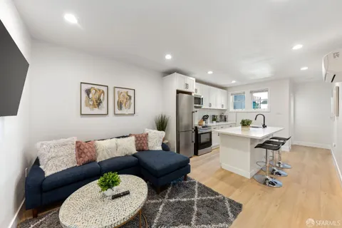 a living room with lots of furniture and view of kitchen