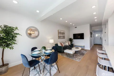 a living room with furniture a large window and a potted plant