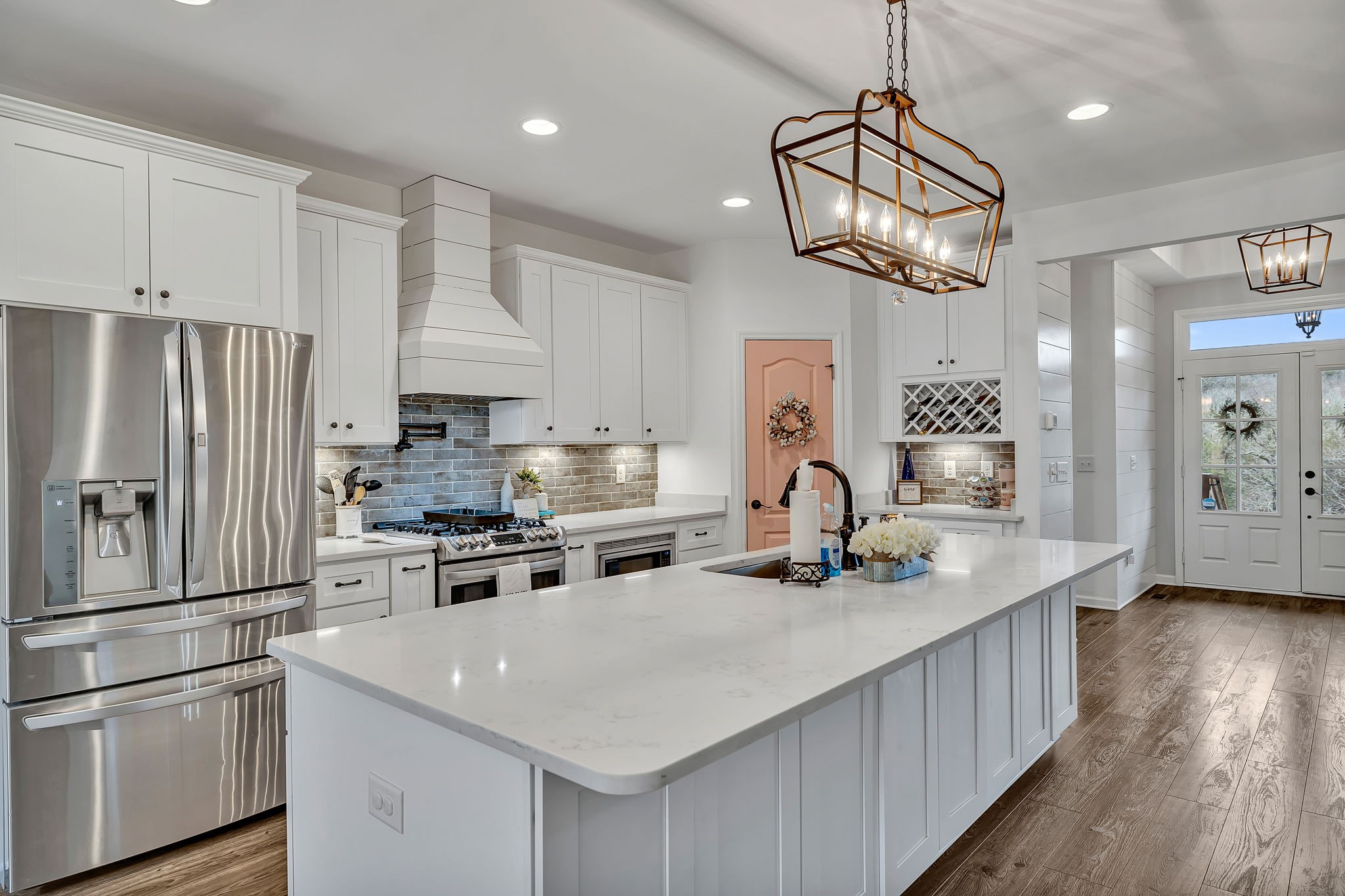 1349 Cliff Amos Road Spring Hill, TN 37174 - Photo 10 of 48 a kitchen with stainless steel appliances granite countertop a sink a stove a refrigerator cabinets and a dining table with wooden floor