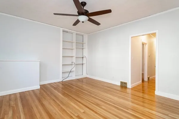a view of empty room with wooden floor