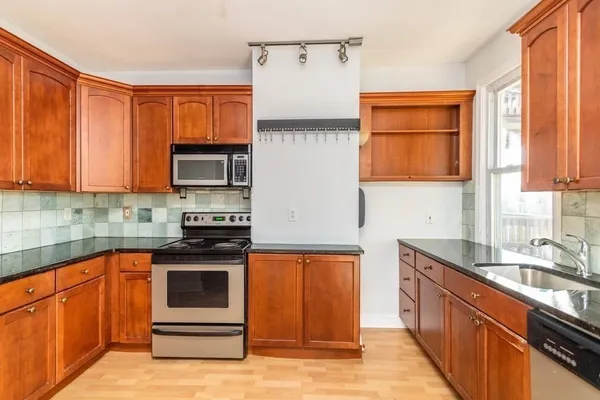 a kitchen with stainless steel appliances granite countertop a sink stove and microwave