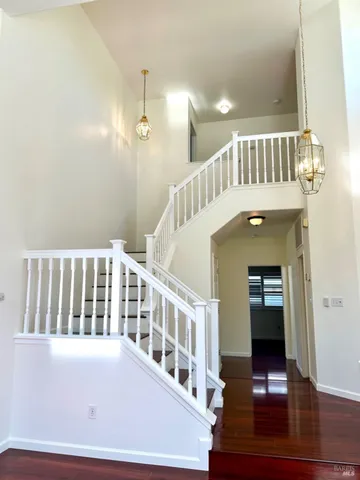 an empty room with wooden floor fireplace and windows