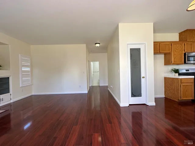 a kitchen with stainless steel appliances granite countertop a stove a sink and a refrigerator with wooden floors