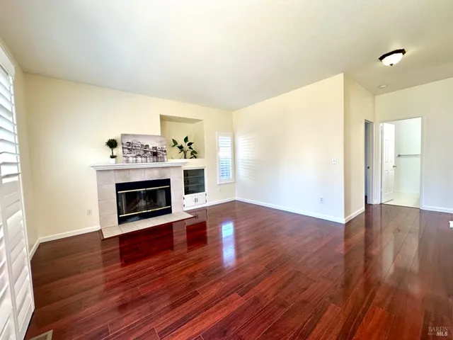 a view of a livingroom with furniture wooden floor a chandelier and windows