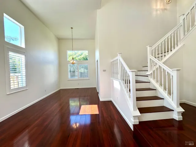 a view of a living room with furniture and wooden floor