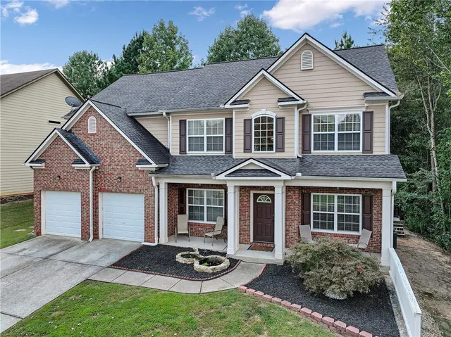 an aerial view of a tennis ground and a cars park side of the road