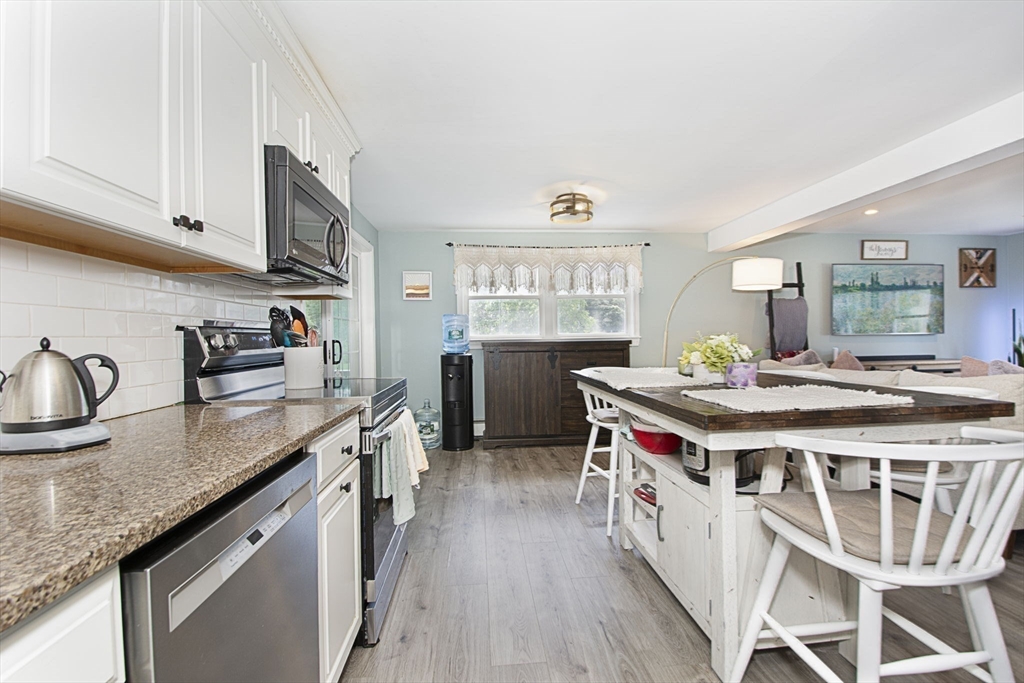 14 Robbins Road Ayer, MA 01432 - Photo 6 of 24 a kitchen with stainless steel appliances granite countertop a stove a sink dishwasher and cabinets with wooden floor