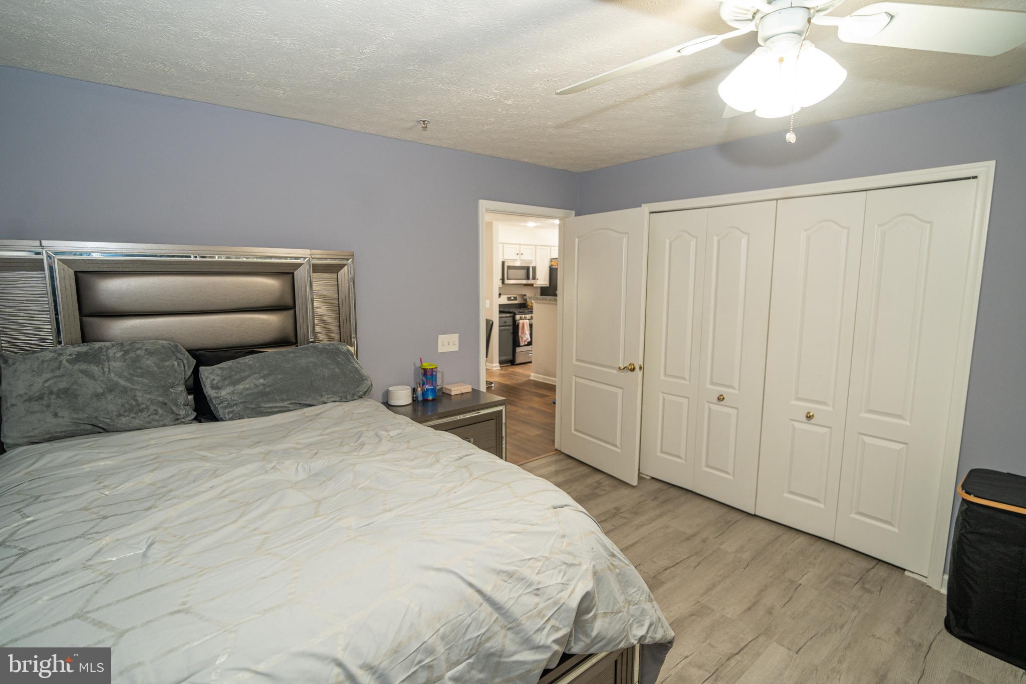 8911 Town Center Circle, Unit 4102 Upper Marlboro, MD 20774 - Photo 12 of 16 a spacious bedroom with a bed and a chandelier