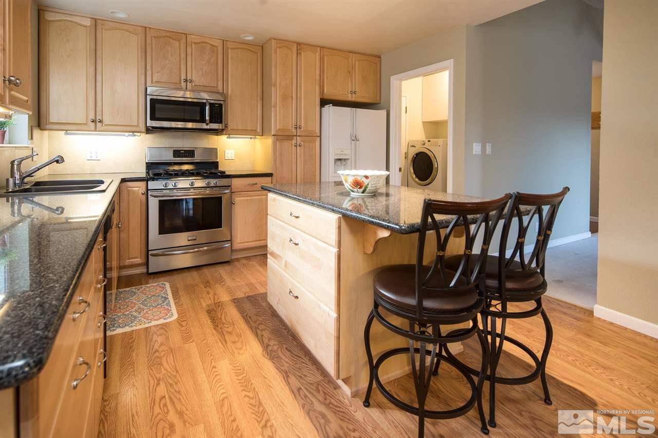 2910 Severn Drive Reno, NV 89503 - Photo 6 of 23 a kitchen with stainless steel appliances kitchen island granite countertop a table chairs microwave and sink