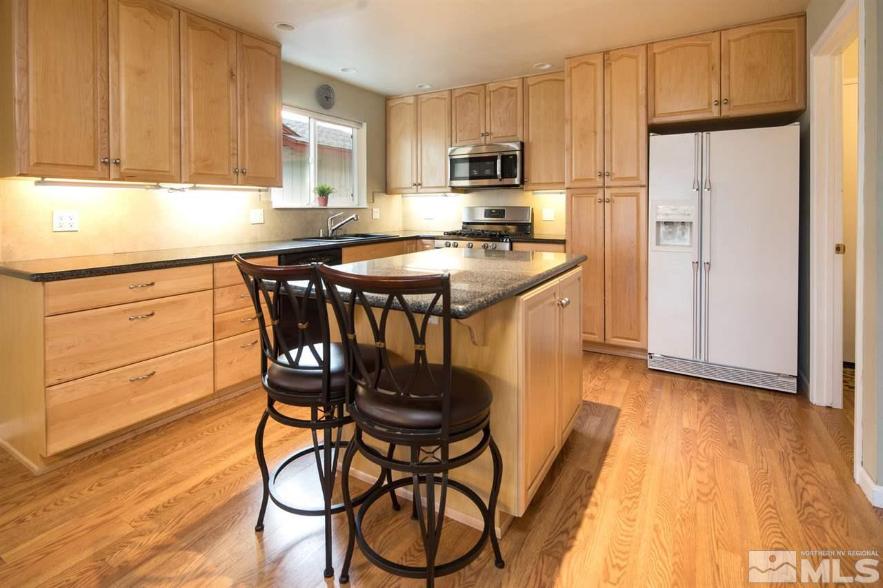 2910 Severn Drive Reno, NV 89503 - Photo 8 of 23 a kitchen with stainless steel appliances a dining table chairs a refrigerator and cabinets