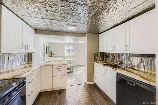 a kitchen with a sink stove cabinets and wooden floor