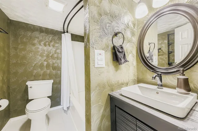 a bathroom with a sink a mirror a toilet and a shower