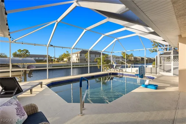 a view of a patio with couches table and chairs under an umbrella