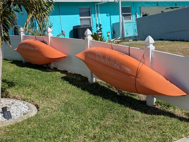 a view of a backyard with lawn chairs under an umbrella