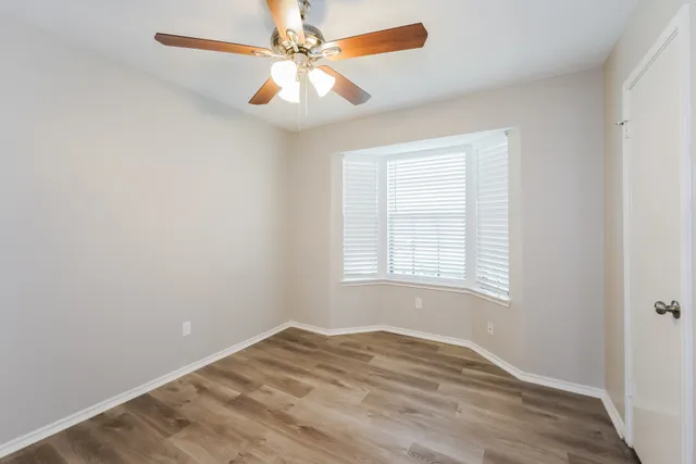 an empty room with a window and a fan
