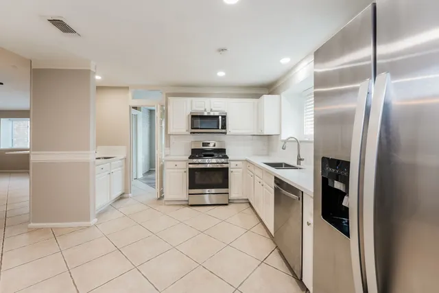 a kitchen with granite countertop a refrigerator and a stove top oven