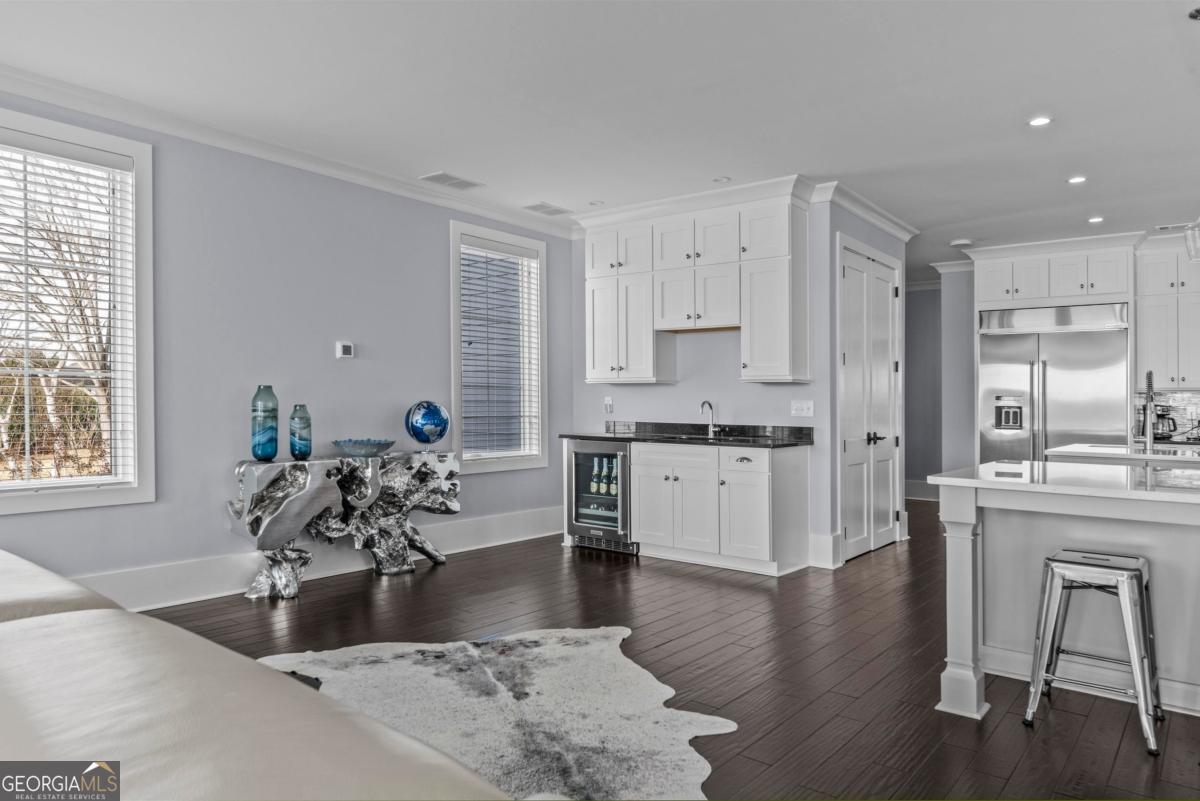 312 Cold Branch Road Eatonton, GA 31024 - Photo 32 of 75 a kitchen with granite countertop a stove a sink a refrigerator and white cabinets with wooden floor
