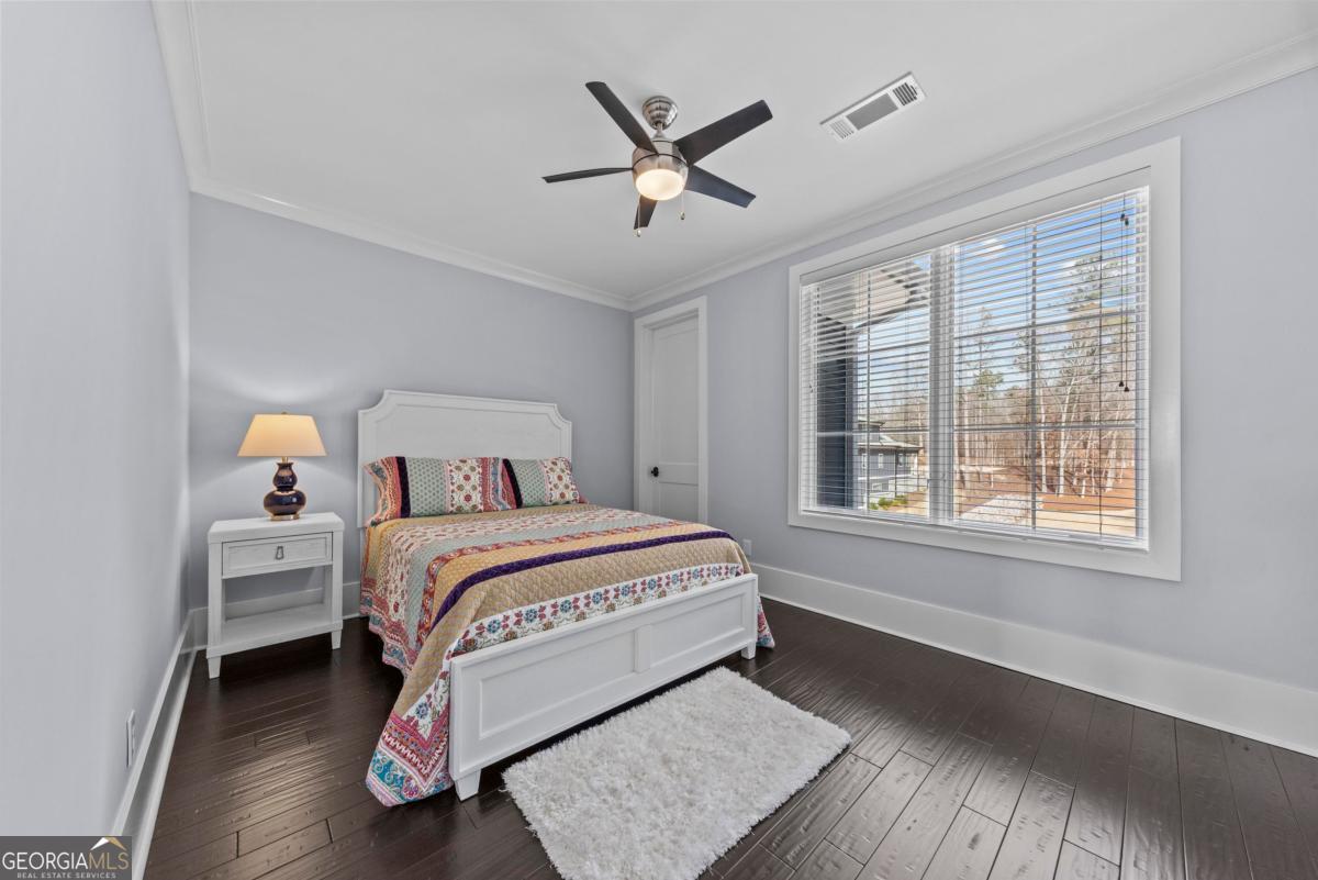312 Cold Branch Road Eatonton, GA 31024 - Photo 61 of 75 a bedroom with a large bed chandelier and a window