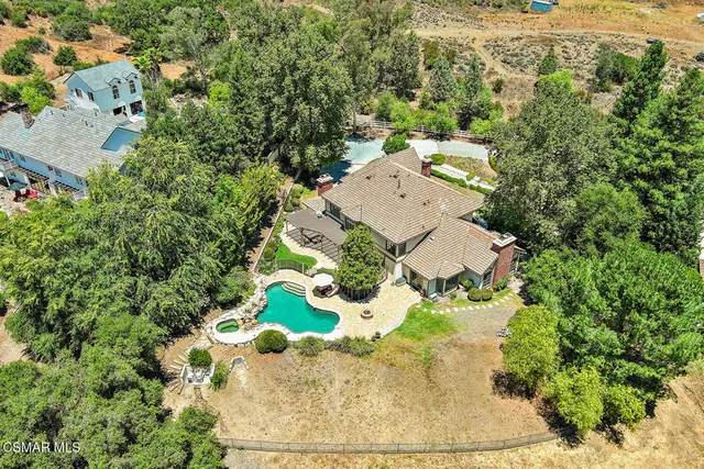an aerial view of a house with a yard and trees
