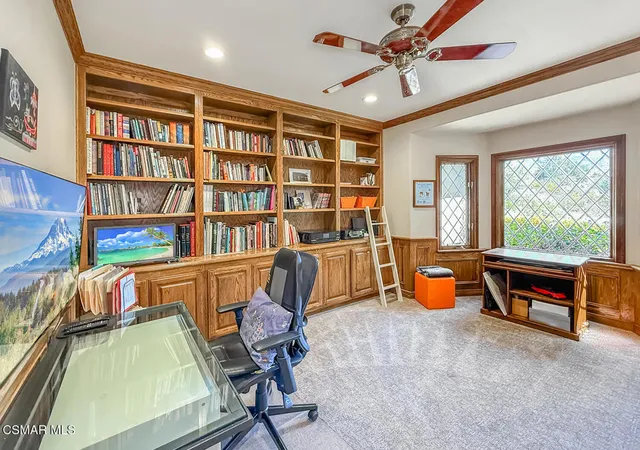 a view of a workspace with furniture and a bookshelf