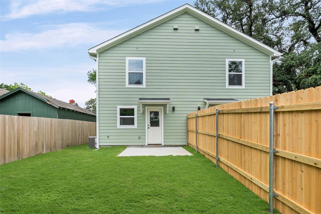 1536 Alexander Avenue, Unit A & B Waco, TX 76708 - Photo 9 of 30 Rear exterior featuring light green siding, a white entry door with an awning, multiple windows, a concrete patio, and a wooden privacy fence
