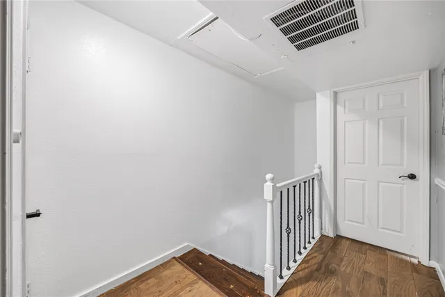 a view of a hallway with wooden floor and entryway