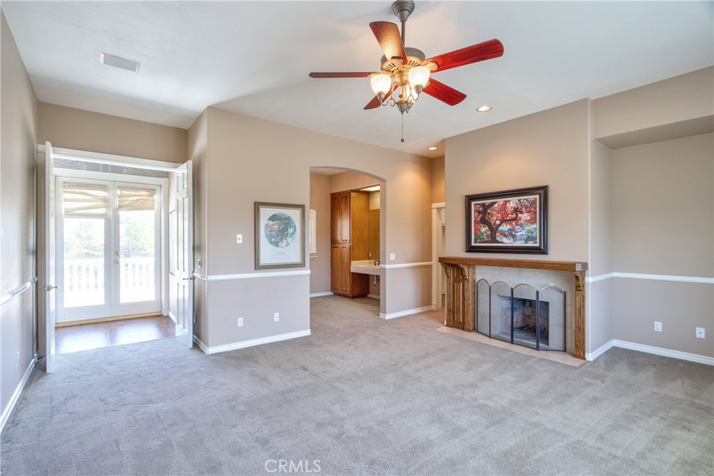 46856 El Prado Road Temecula, CA 92590 - Photo 44 of 75 a view of a livingroom with a fireplace a ceiling fan and wooden floor