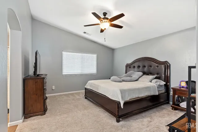 a bedroom with a bed and a ceiling fan