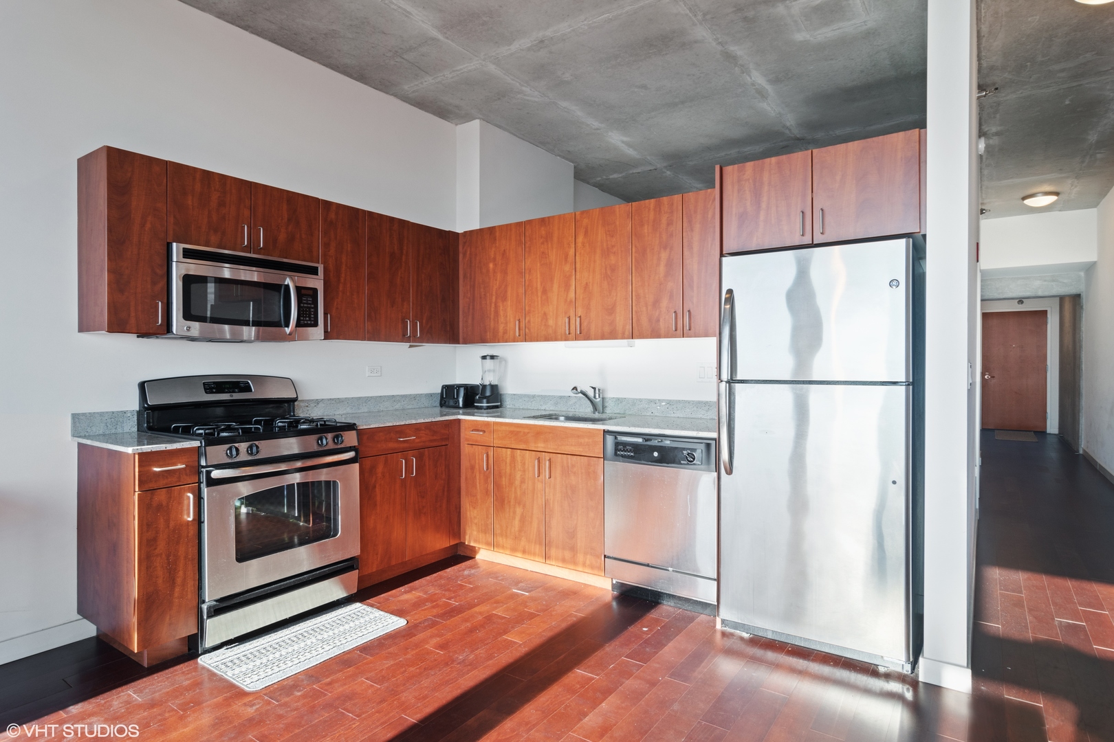 235 West Van Buren Street, Unit 3706 Chicago, IL 60607 - Photo 4 of 13 a kitchen with granite countertop a refrigerator stove and microwave