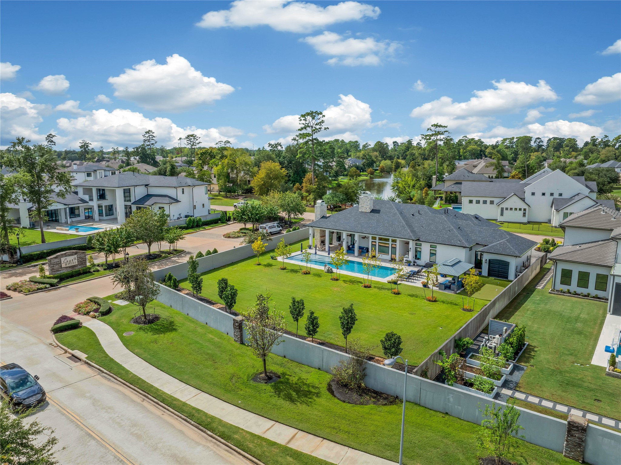 24718 Shadow Pond Spring, TX 77389 - Photo 47 of 49 Sprawling modern estate with a luxurious pool, expansive lawn, and scenic water views, nestled in a tranquil, upscale neighborhood.