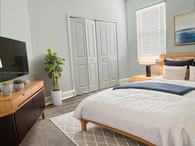 a bedroom with a bed and a flat screen tv