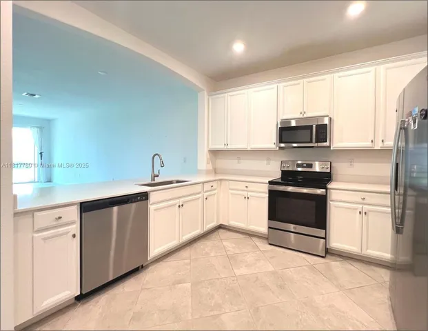 a kitchen with stainless steel appliances and white cabinets