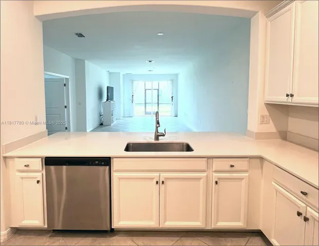 a kitchen with white cabinets and sink
